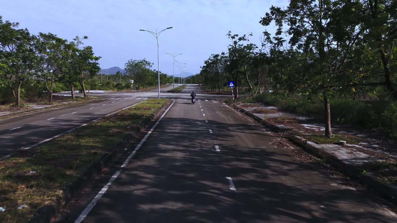 Terbang di belakang sepeda motor di area yang tampak seperti kiamat.