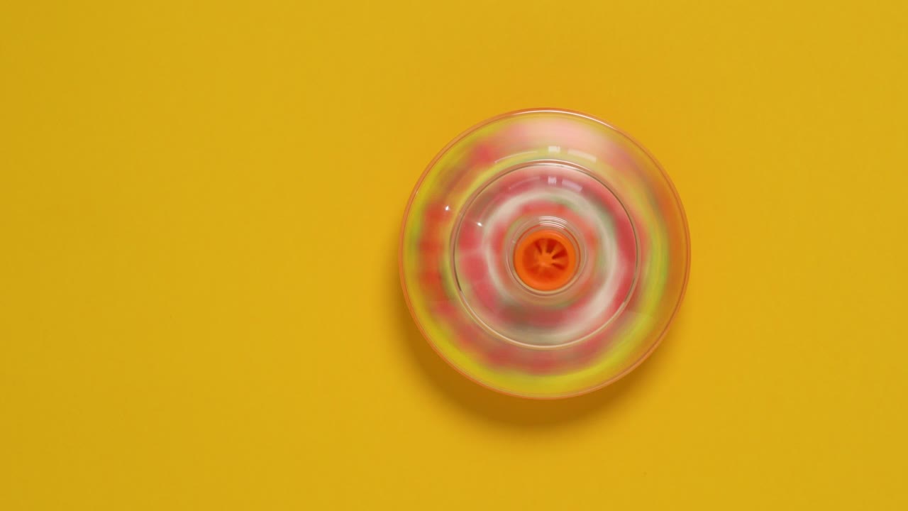 juguete giratorio colorido sobre fondo amarillo