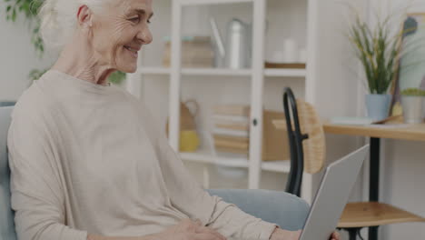 mujer mayor usando una computadora portátil en casa