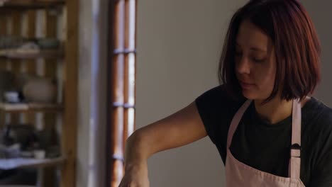 Young-female-potter-working-in-her-studio