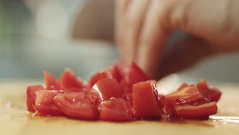 out of focus scene of young guy cutting tomatoes on wooden table in kitchen for prepare pasta