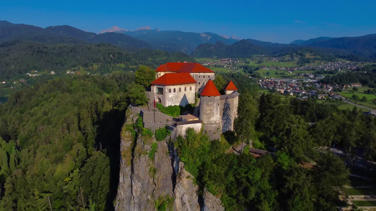Aerial 4K drone view circling Bled Castle on sunny summer morning - Lake Bled, Slovenia