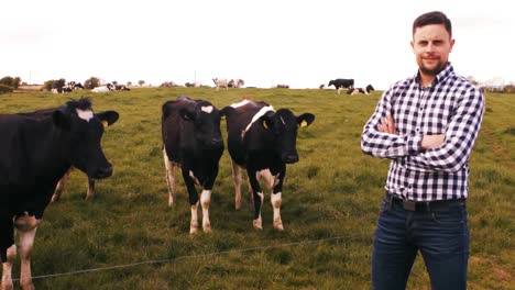 man standing with herd of cattles in the field