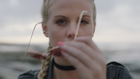 retrato en primer plano de una mujer rubia atractiva que se quita las gafas de sol y se ve confiada ante la cámara