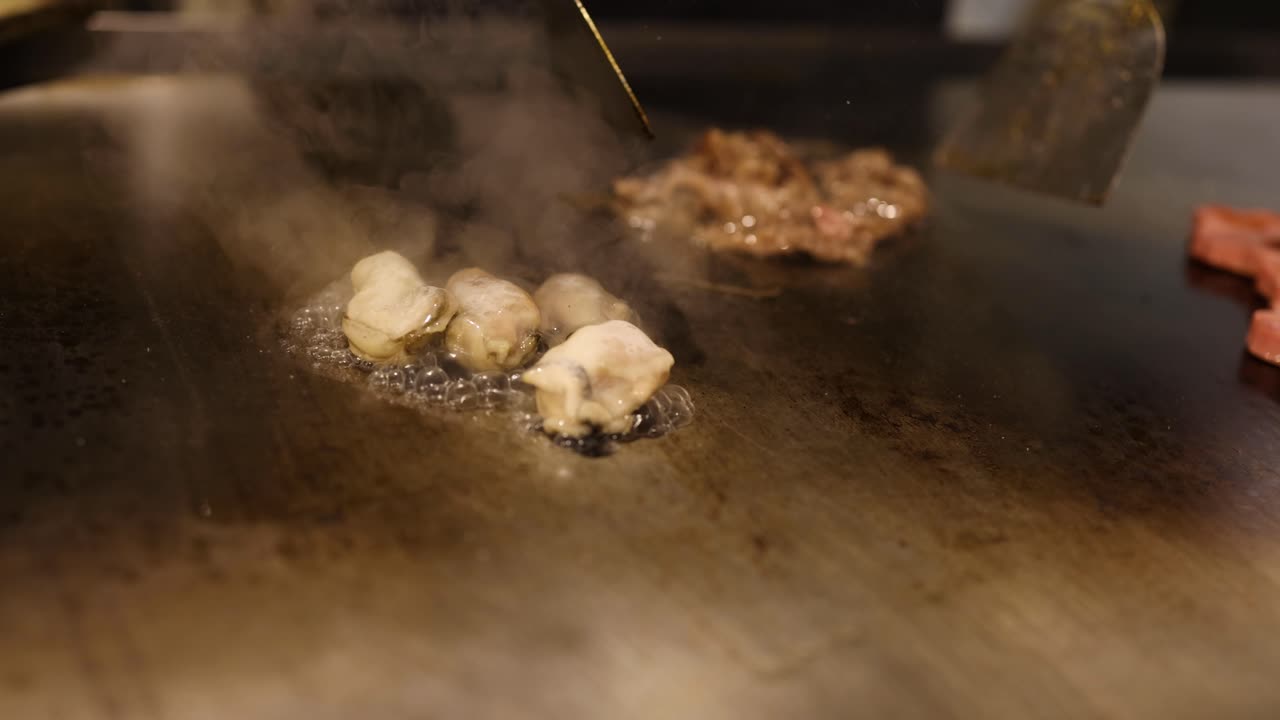 요리사는 뜨거운 그릴에서 맛있는 음식을 준비합니다.