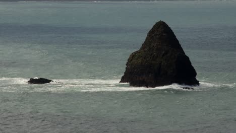 Mittlere-Aufnahme-Von-Möwenfelsen-Und-Wellen,-Die-Darauf-Prallen