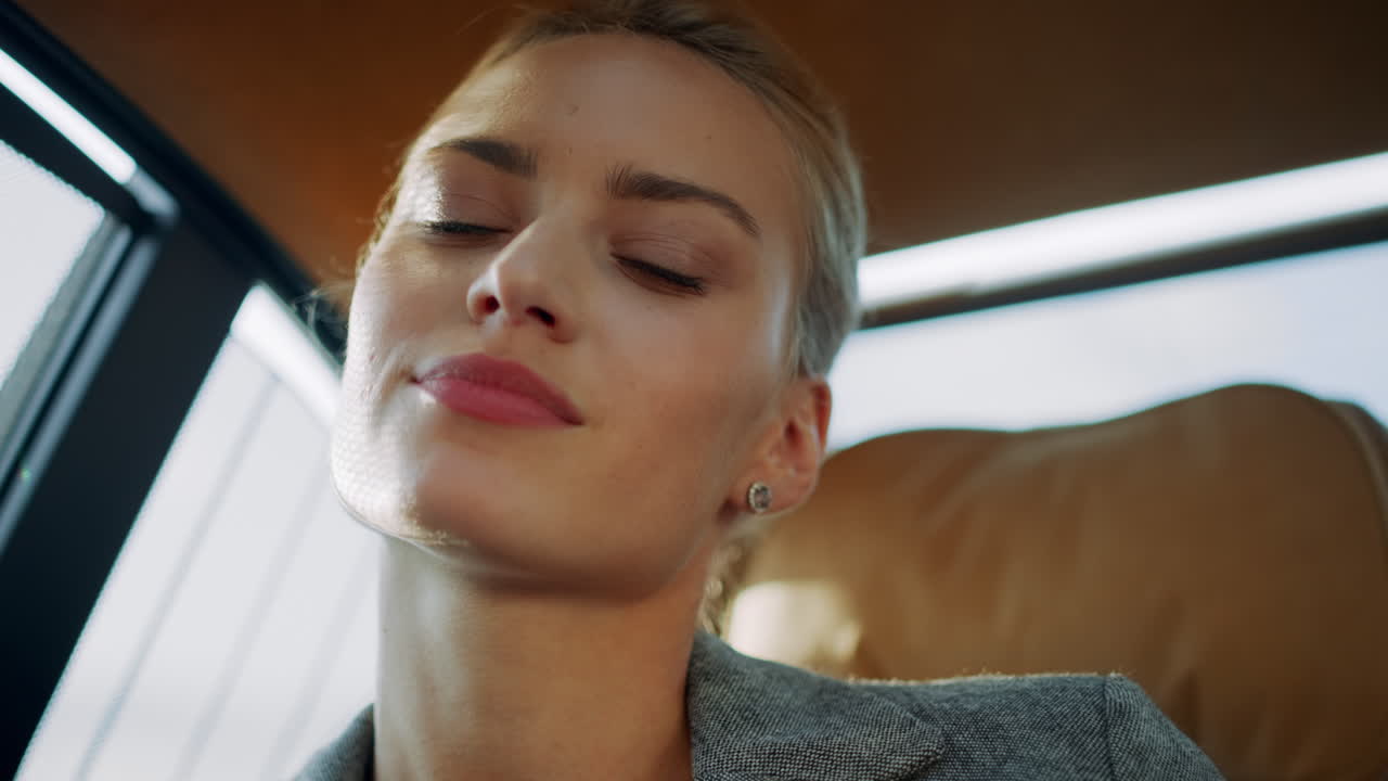 Ritratto di una bella donna d'affari che balla in auto. Ragazza che muove le mani in un'auto moderna.