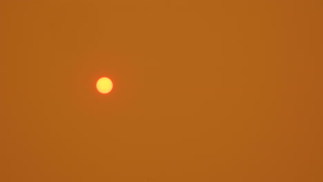 Orangefarbene-Sonne-Im-Rauchigen-Orangefarbenen-Himmel,-Während-Sich-Asche-Auf-Der-Linse-Absetzt