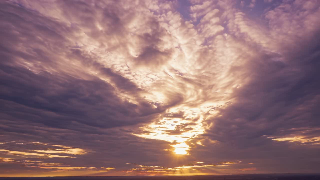 A stunning aerial video captures a dramatic sunset with swirling clouds