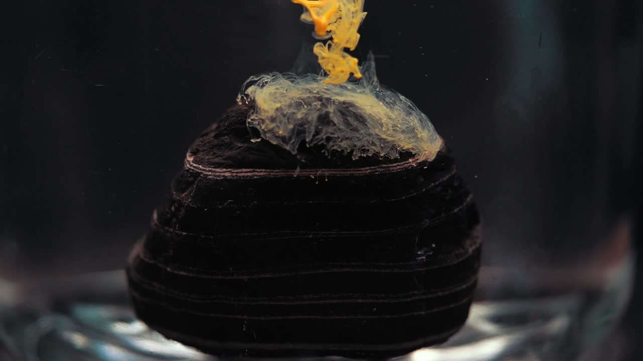 Slowmotion paint floating inside water tank, beautiful layered rock. Stable shot with the Sony a7iii.