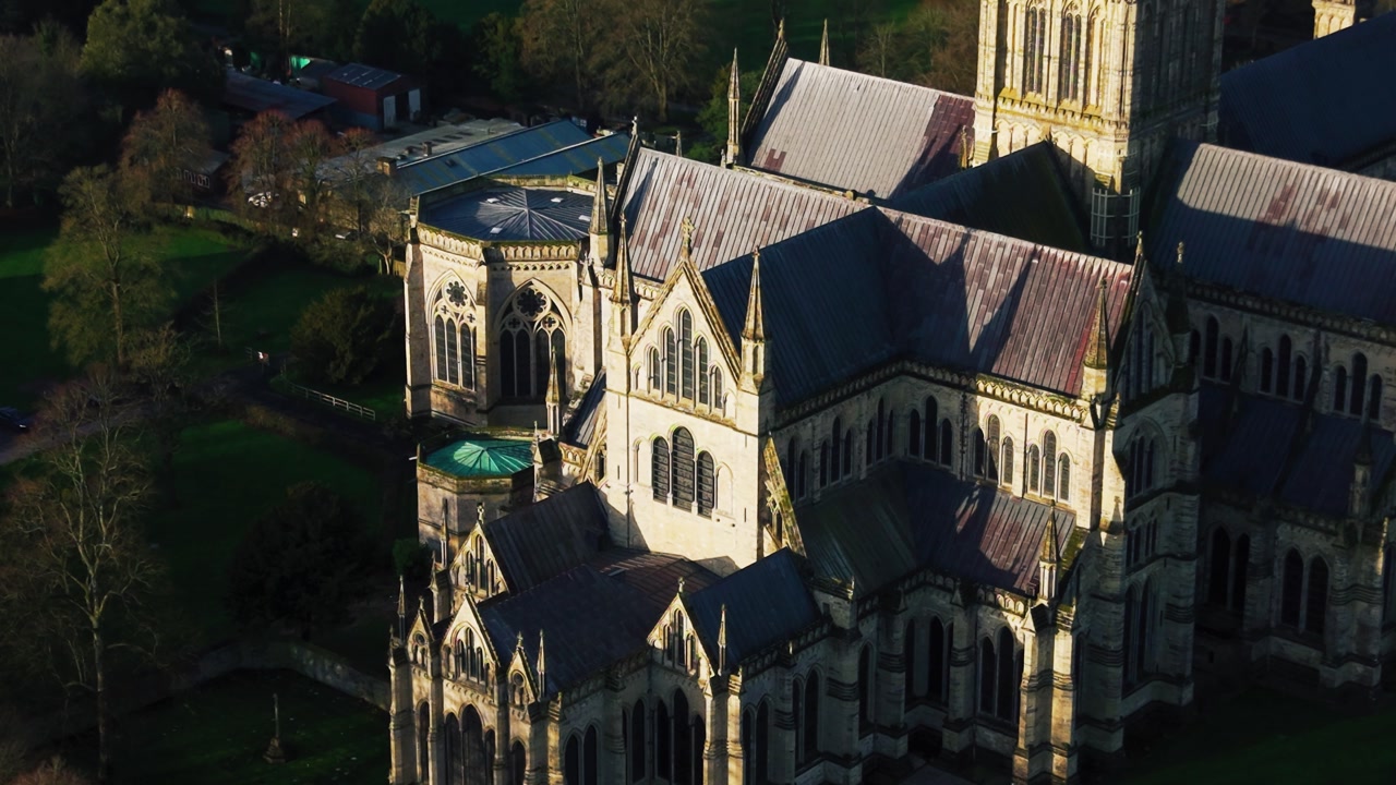 Close aerial view of Salisbury Cathedral highlighting gothic architectural detail and roof structures in warm golden hour light in Wiltshire England