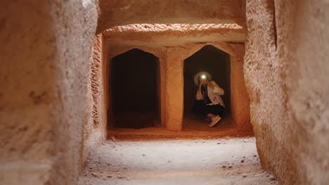 mujer explorando un túnel de cueva