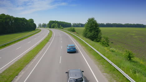 blue luxury car on road on the field background. very fast driving of audi car on highway under beautiful sky at daylight.