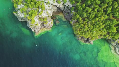 Aerial-shot-of-the-turquoise-water-by-the-cliffs
