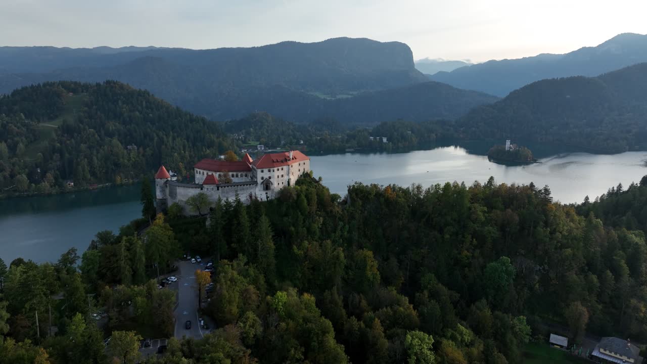 Vista aerea panoramica con drone del Castello di Bled che domina il Lago di Bled, le colline boscose e il paesaggio delle Alpi Giulie in Slovenia