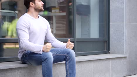 ansioso serio hombre guapo sentado fuera de la oficina