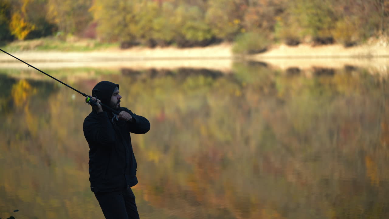 Man fishing in a lake during autumn