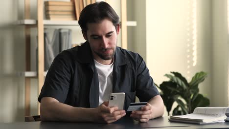 hombre tiene teléfono móvil y tarjeta de crédito disfruta de las compras móviles en línea