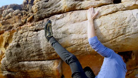 Male-hiker-climbing-rocky-mountain-in-countryside-4k