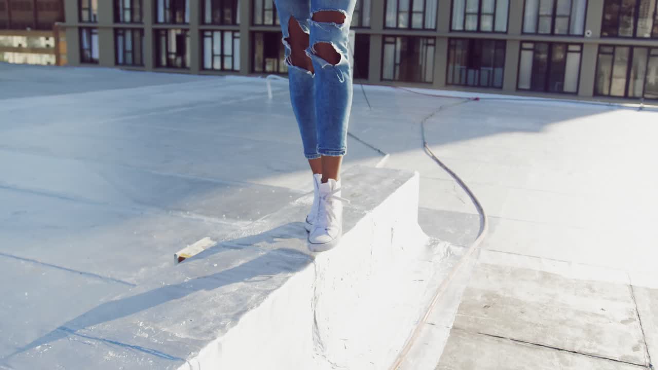 Legs of fashionable young woman walking on urban rooftop
