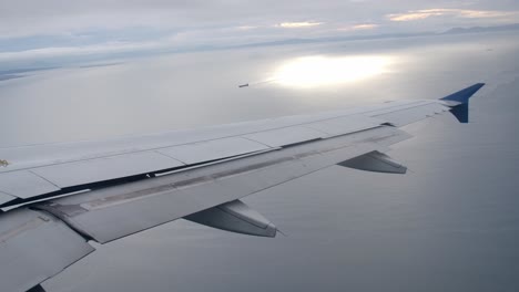 de-banking airplane in flight, passenger view of aircraft wing