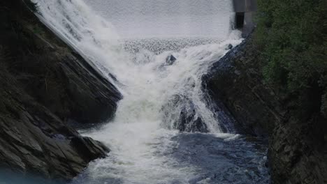 strong flowing stream down into rocks covered with moss in coaticook river valley, quebec canada, slow motion