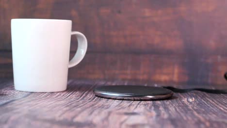 wireless charger and mug on wooden table