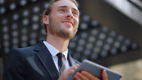 Sly-businessman-smiling-someone-outside.-Serious-guy-using-tablet-outdoors