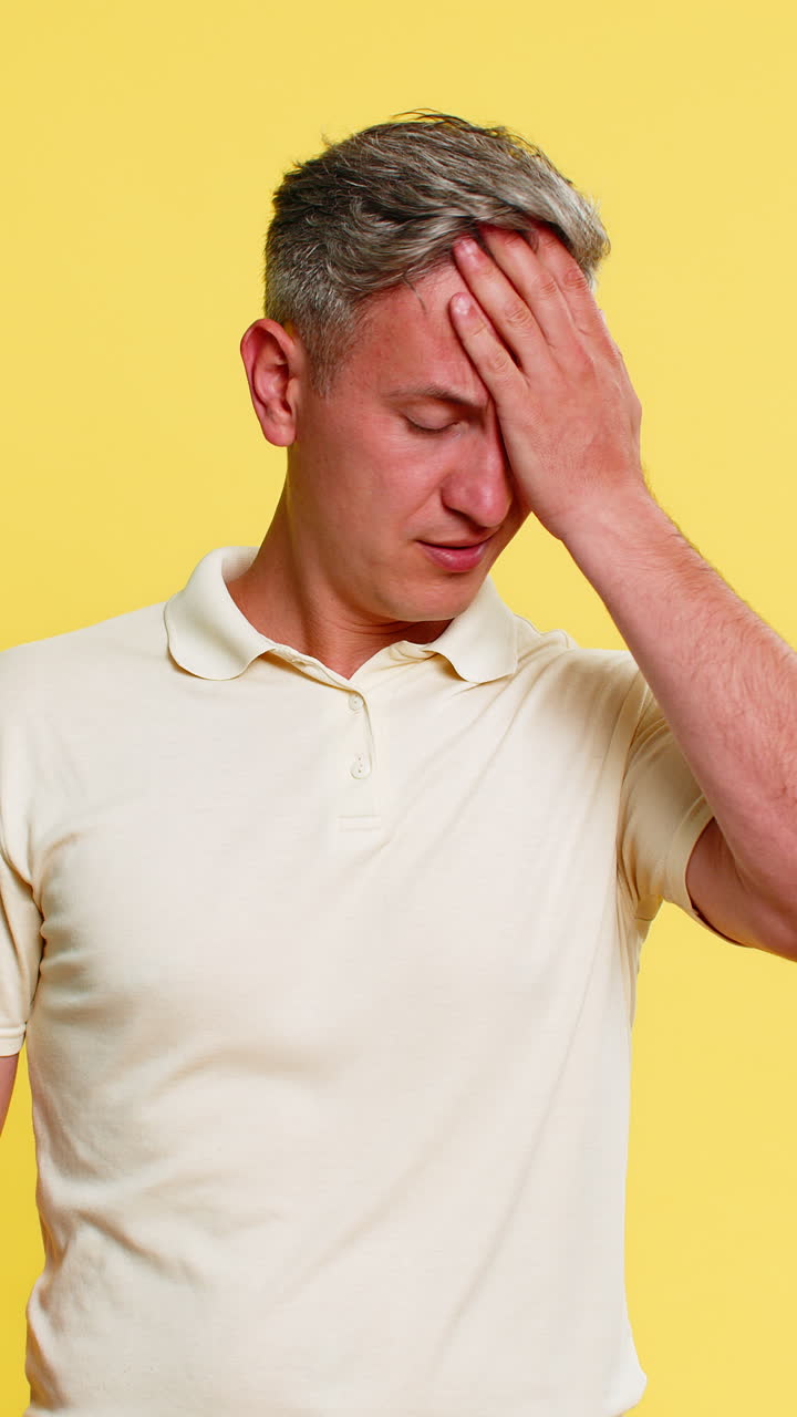 Adult man showing facepalm with tired disappointed expression symbolizing failure stress frustration