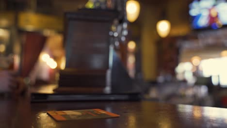 having a drink of a brown ale and placing it on bar top