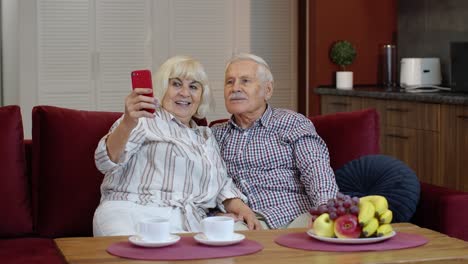 Senior-family-having-fun,-making-selfie-photos,-recording-video-together-on-smartphone-at-home