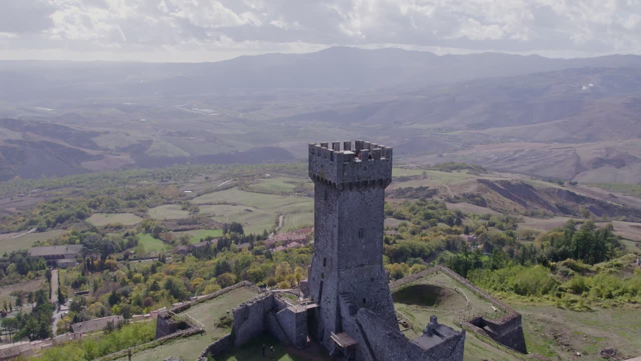 Luftfoto af Radicofanis ikoniske fæstning midt i bølgende bakker, Toscana, Italien
