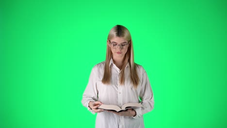 intellectual young blonde woman reading book with green background, studio shot