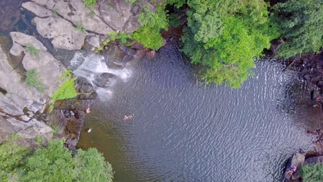 cascada y su estanque, la toma es tomada por un dron donde el dron gira alrededor de su eje con una vista de pájaro del estanque