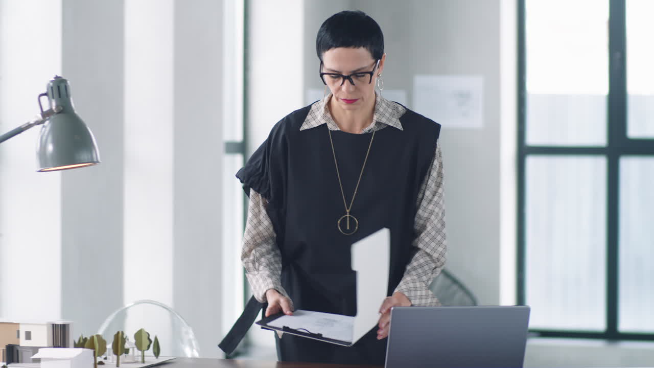 mujer de negocios elegante caminando en la oficina y comprobando documentos