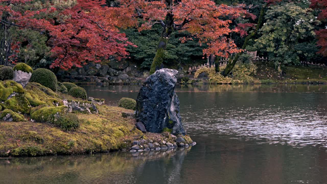 Kanazawa's Kenroku-en Gardens lake at Sunset with red foliage in autumn, Japan