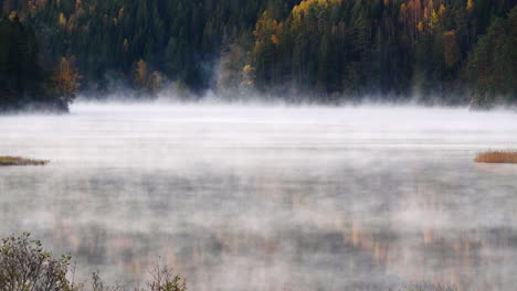 Niebla-Mística-Rodando-Sobre-El-Lago-Alpino-En-El-Bosque-De-Otoño,-Lapso-De-Tiempo