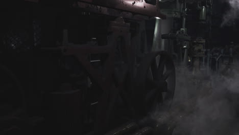 dark industrial setting showcasing machinery with steam in workshop