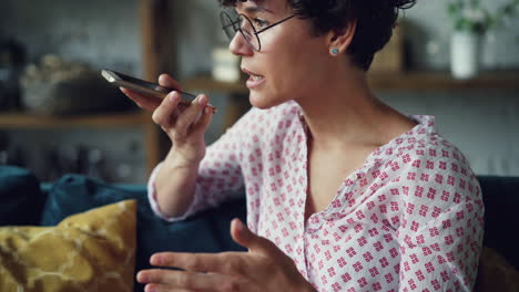woman using voice assistant on smartphone at home