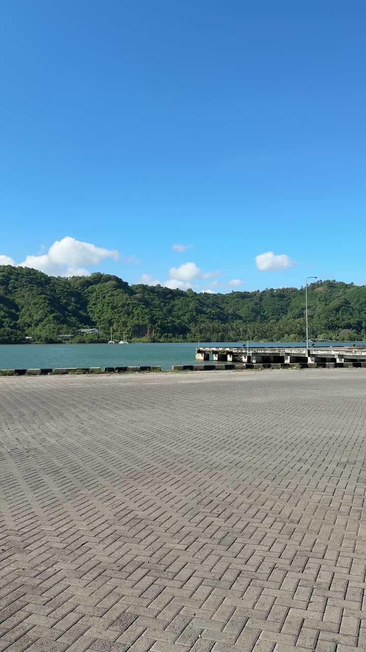 人影のない桟橋から望む穏やかな熱帯の湾と緑豊かな山々