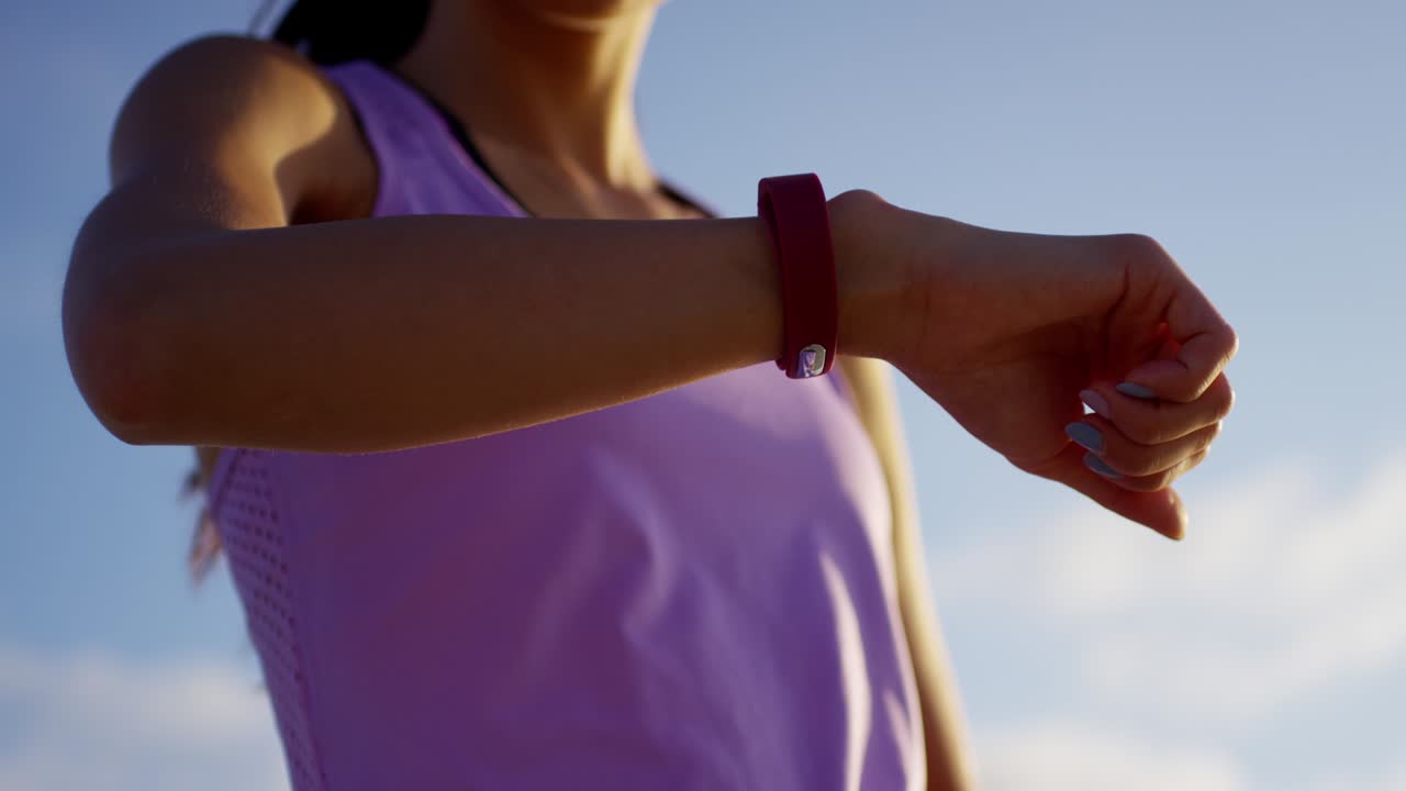 Asiatische Frau beim Cardiotraining mit Smartwatch.