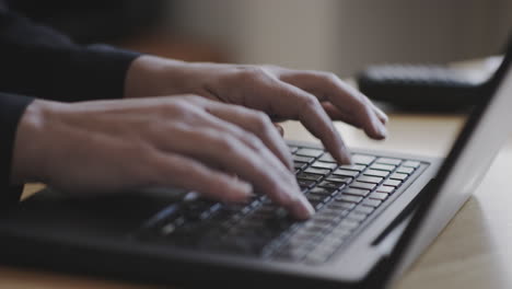 young woman works on a laptop