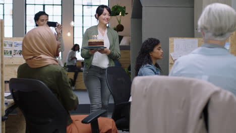 feliz gente de negocios celebrando fiesta de cumpleaños emocionado colega soplando velas disfrutando sorpresa equipo de la oficina animando juntos en una celebración diversa lugar de trabajo