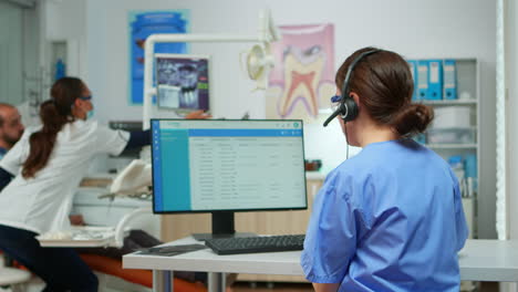 asistente de dentista haciendo citas usando auriculares