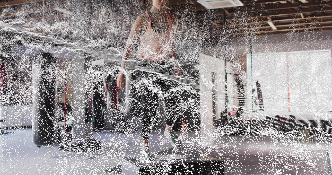 Appassionato di fitness che piega le ginocchia per generare un'onda di energia, poi si accovaccia e salta su una plyo box.