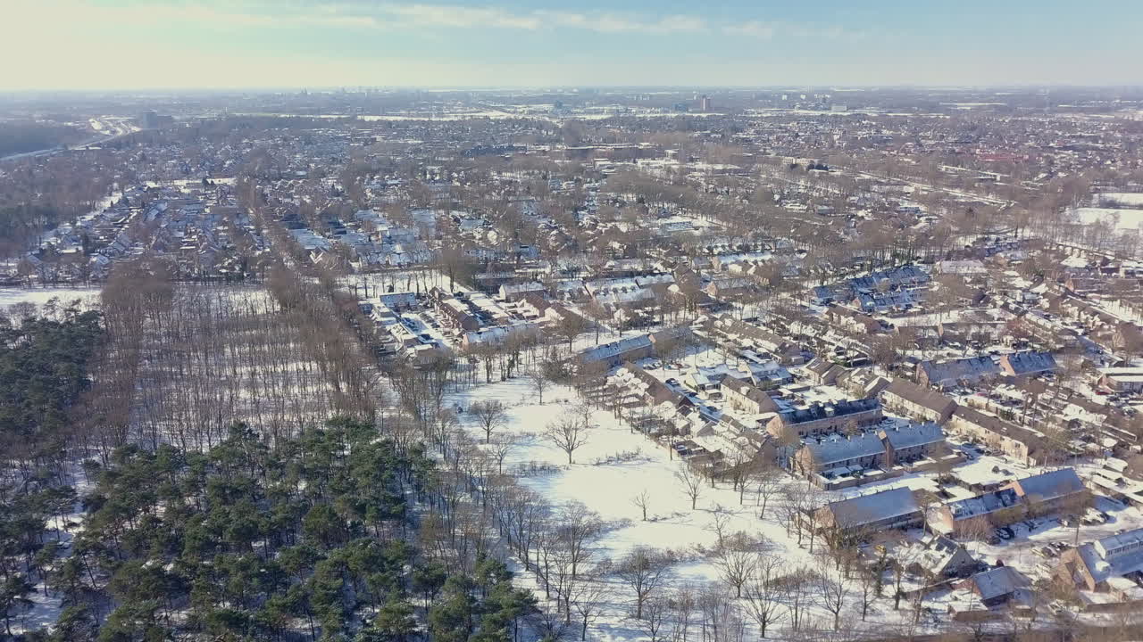 aerial drone shot of flying up at the snowy suburban area in the Netherlands
