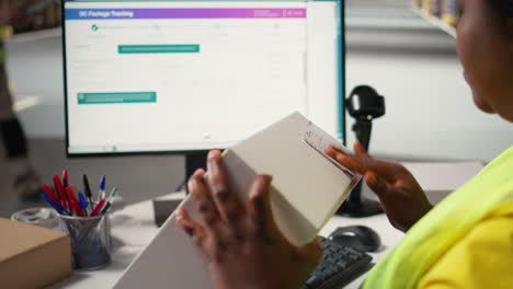 vertical video black woman packing goods and applying shipping labels on boxes