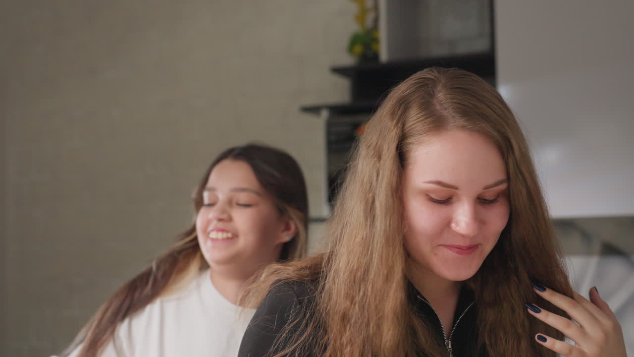 Buddy in kitchen as friend covers eyes playfully then releases both laugh warm candid moment soft daylight on hair casual home scene hands over face joyful surprise domestic fun genuine reaction