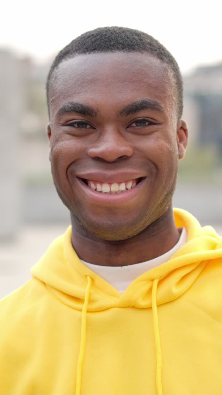 African young man standing outdoors and smiling