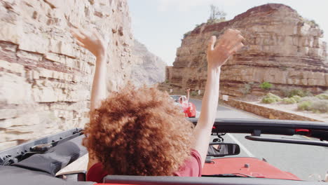 una pareja joven conduciendo un coche de alquiler abierto en las vacaciones de verano.